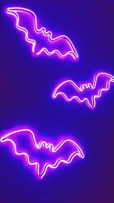 two neon signs with bats on them in front of a purple background, one is lit up