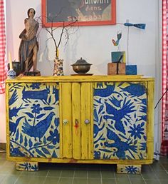 a yellow cabinet with blue and white designs on it