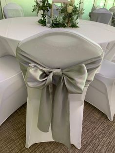 the back of a chair with a bow on it's sashring at a banquet table