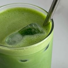 a green smoothie in a glass with a straw