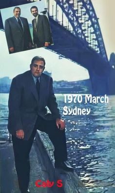 a man in a suit and tie sitting on a boat near the sydney harbour bridge