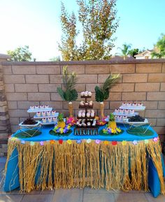 a table topped with lots of desserts next to a brick wall