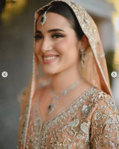 a woman in a bridal gown smiles at the camera