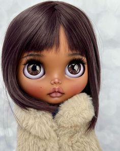 a close up of a doll with long brown hair and big eyes wearing a fur coat