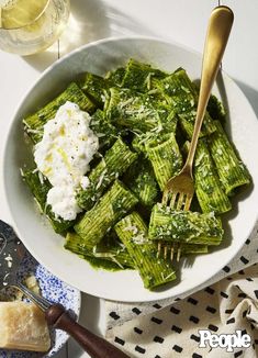 a white bowl filled with green vegetables and cottage cheese