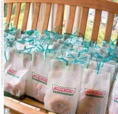 many bags are sitting on a bench with blue ribbon tied around the top and bottom