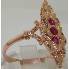 *This unique long elliptical shape design ring is made from 375 9K Rose Gold with Natural Ruby.PLEASE MAKE SURE YOU STATE THE FINGER SIZE YOU REQUIRE WITH YOUR PAYMENT.A beautiful Vintage Style Ruby Ring set with one 2.5mm (0.10" inches) and two 2mm (0.08" inches) colorful vibrant Rubies in a gorgeous 9K Rose Gold cluster setting.A really impressive ring and unusual in design. Completely made from Solid English 9K Gold Hallmarked by the London Assay Office which confirms the rings authenticity. Victorian Style 14k Rose Gold Ruby Ring, Oval Rose Gold Hallmarked Ruby Ring, 14k Rose Gold Marquise Rings, Marquise Rose Gold 14k Rings, Victorian Style Rose Gold Ruby Ring, Heirloom Marquise Rose Gold Rings, Heirloom Rose Gold Oval Ruby Ring, Heirloom Rose Gold Marquise Rings, Hallmarked Rose Gold Ruby Ring