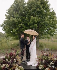 a bride and groom standing under an umbrella