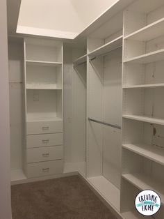 an empty walk in closet with white shelving and shelves on each side, along with carpeted flooring