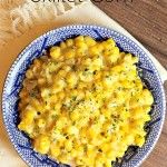 a blue bowl filled with macaroni and cheese on top of a wooden table