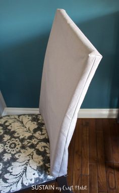 an upholstered chair with a black and white damask seat cover on it