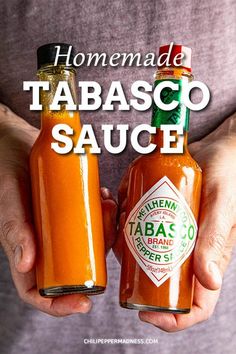 someone holding two jars of tabasco sauce in their hands