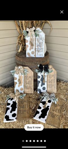 some cow print gift bags are stacked on top of hay