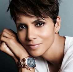 a close up of a person with a watch on her wrist and wearing a white shirt