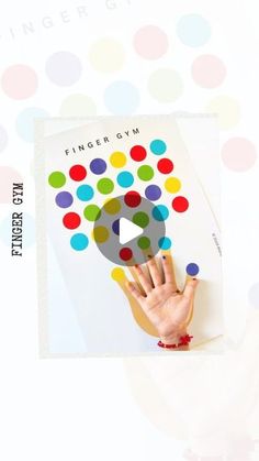 a person holding up a finger gym card with colorful dots on the front and bottom