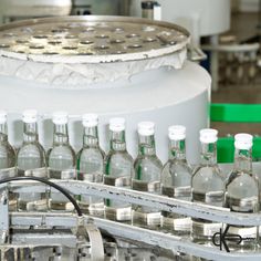 bottles are lined up on a conveyor belt in an industrial factory or assembly line