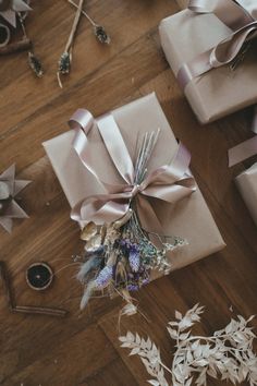 several wrapped presents are on the floor with ribbons