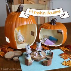 two pumpkin houses are sitting on a table