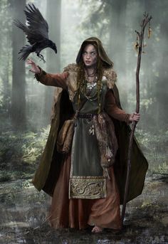 a woman dressed in medieval clothing holding a crow