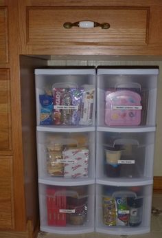 an organized pantry with plastic containers and food in the bottom half, on top of a wooden countertop