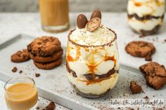 desserts with cookies and milk on a tray next to two glasses of orange juice