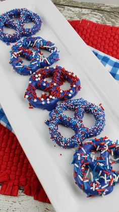 three donuts with sprinkles and red white and blue are on a plate