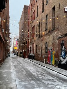 an alleyway with graffiti on the side and string lights strung across the walkways