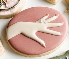 cookies decorated with icing and fondant are arranged on a table next to sewing supplies