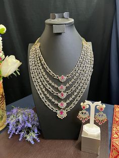 AD Dimond Ruby Pink Doublet AD Stone/ Long Haram with Earrings 30.0 Inches Long/Gold Finish/Bridal Haram/Indian Jewelry/Pakistani Jewelry This item is perfect for parties and festivals! DETAILS: Includes One Long Haram and two Earrings. Necklace: 30.0 inches long . Adjustable length. Chain closure. Weighs 6.20 oz ( 176g).  Earrings: 2 .8 inch(es) long. Earring set weighs 0.80 oz (23 g). Earring backs push on/off. Material: Imitation  Gold Polish with GJ Finish Pearl Drop, Emerald AD Stones. Fini Traditional Diamond Sets For Formal Occasions, Traditional Formal American Diamond Sets, Traditional Silver Sets For Reception, Silver Traditional Sets For Reception, Reception Bridal Sets With Stone Work And American Diamond, Silver Bridal Necklace With Zari Work, Silver Bridal Necklace With Zari Work For Reception, Stone Work Jewelry Sets For Reception, Bollywood Stone Work Sets For Celebration