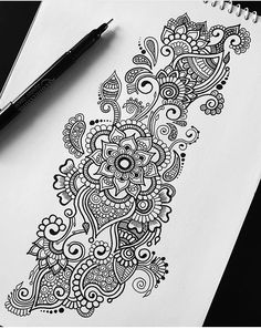 a pen is sitting on top of a paper with an intricate design in the middle