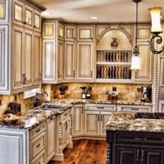 a large kitchen with white cabinets and wood floors