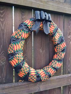 a colorful wreath hanging on the side of a wooden fence