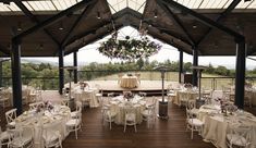 an outdoor venue with tables and chairs set up for a formal function, overlooking the countryside