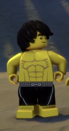 a lego man is standing on the beach