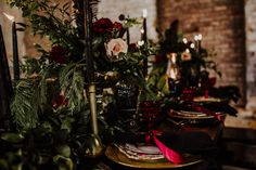 the table is set with candles, flowers and other decorations for an elegant dinner party