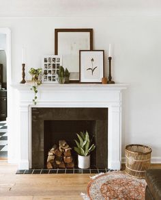 a fireplace with pictures and plants on top