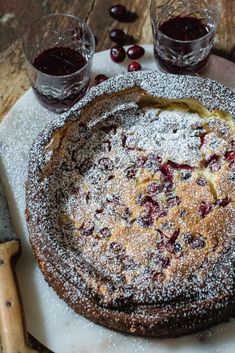 a cake is covered with powdered sugar and cranberries