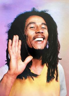 a man with dreadlocks is making the vulcan sign while smiling and holding his hands up in front of him