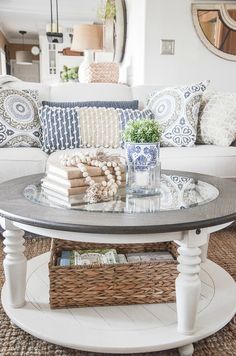 a living room with a couch, coffee table and baskets on the floor in front of it