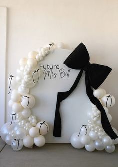 the balloon arch is decorated with white balloons and black ribbon, while it reads future mrs ball