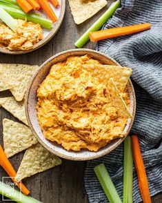 carrots, celery and tortilla chips on a table with dip