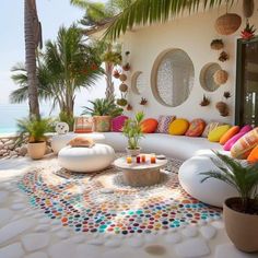 a living room with lots of colorful pillows on the couches and tables in front of it