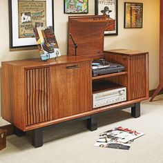 an entertainment center in the corner of a room with pictures on the wall behind it