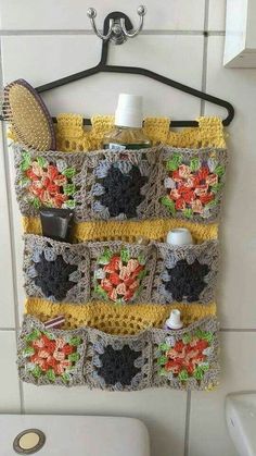 a crocheted towel hanging on the wall next to a toilet