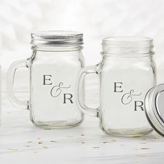 three mason jars with wedding date printed on them, one is empty and the other has a lid