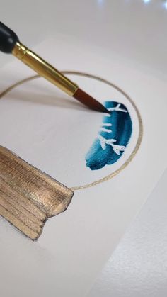 a brush is being used to paint a piece of paper