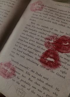 an open book with red lipstick imprints on it's pages and the words