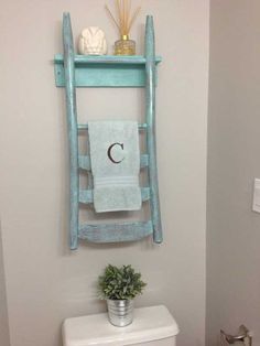 a towel rack with towels on it and a letter c hanging from the wall above it