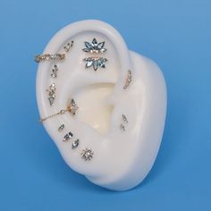 a white ear with jewels on it against a blue background