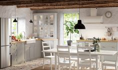 the kitchen is clean and ready to be used for dinner or lunchtime, with all white furniture